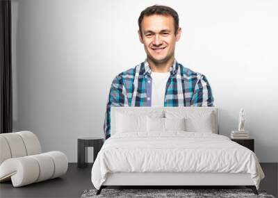 Smiling man standing with arms folded over gray background Wall mural